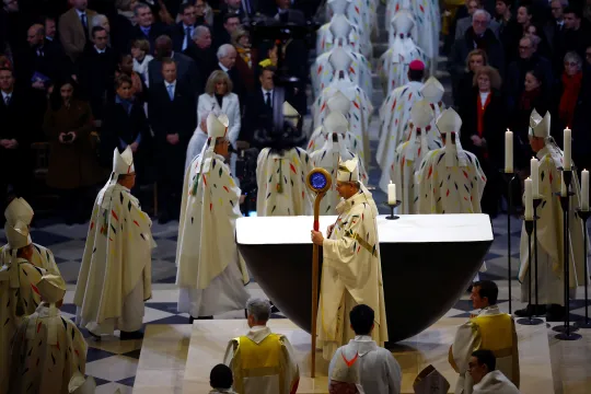 Erkebiskop Laurent Ulrich ser på mens medlemmer av presteskapet forlater skipet etter den første messen i Notre-Dame-katedralen etter brannen i 2019.