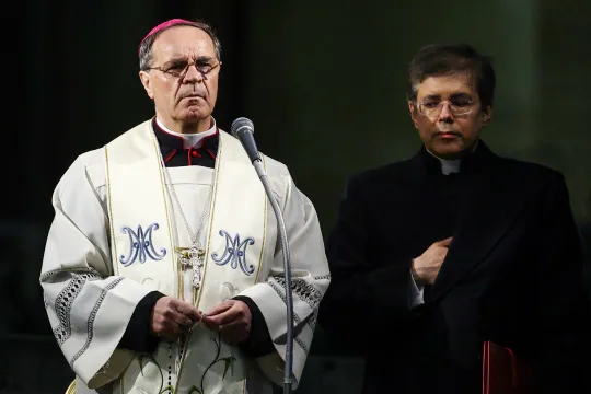 En monsignore ber rosenkransen på Petersplassen, ved siden av en annen prest