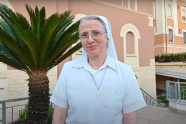 Sr. Simona Brambilla, kledd i hvit, utenfor en bygning i Roma