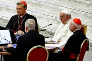 Pave Frans sitter ved et rundt bord med to kardinaler og andre i Paul VI-hallen
