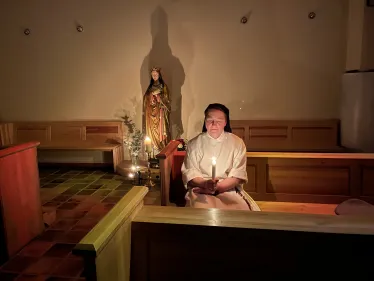 En søster sitter med et lys