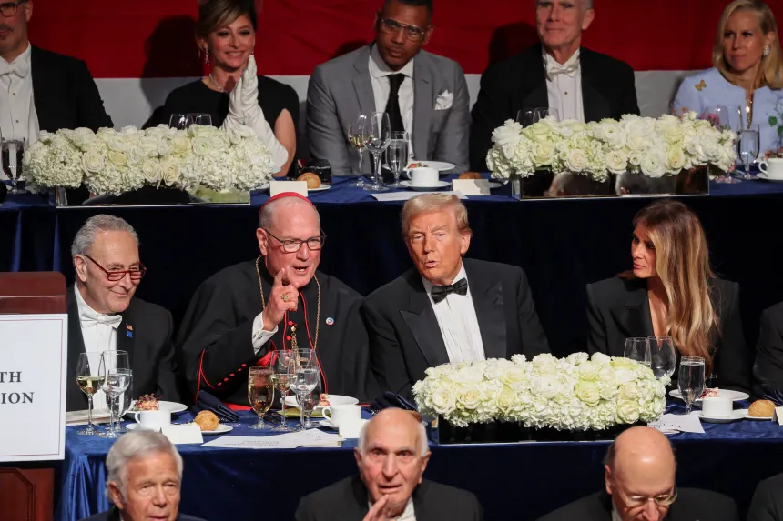 Chuck Schumer, kardinal Dolan, president Trump og Melania Trump sitter på rekke under en middag