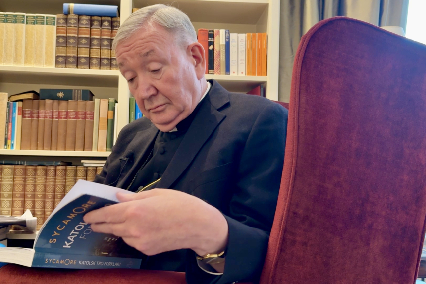Biskop Bernt Eidsvig sitter i en stol og leser et eksemplar av Sycamore-boken