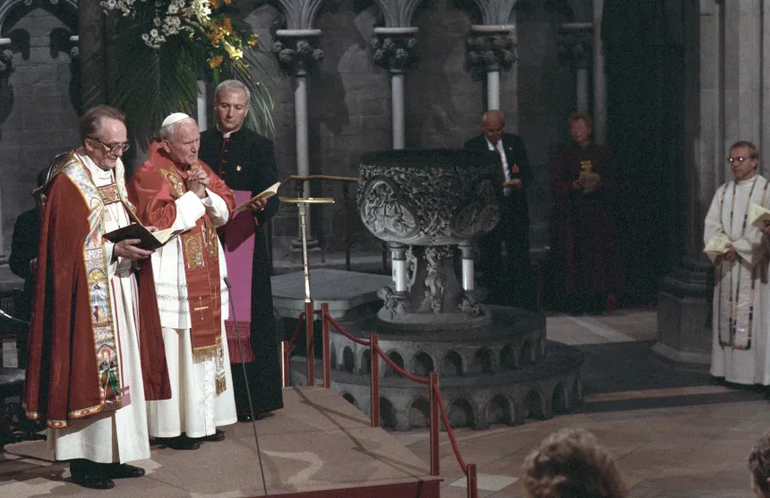 Pave Johannes Paul II står og ber sammen med en luthersk biskop i Nidarosdomen