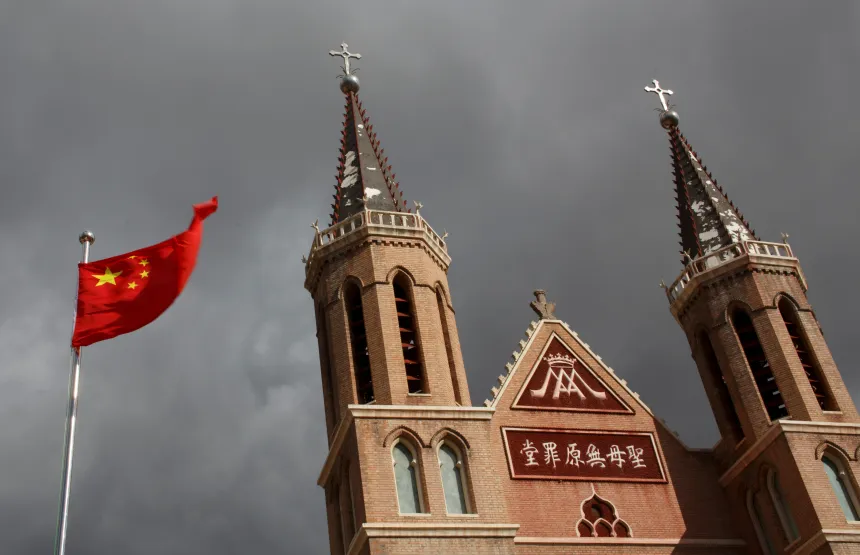 Det kinesiske flagget vaier ved siden av en katolsk kirke i Kina