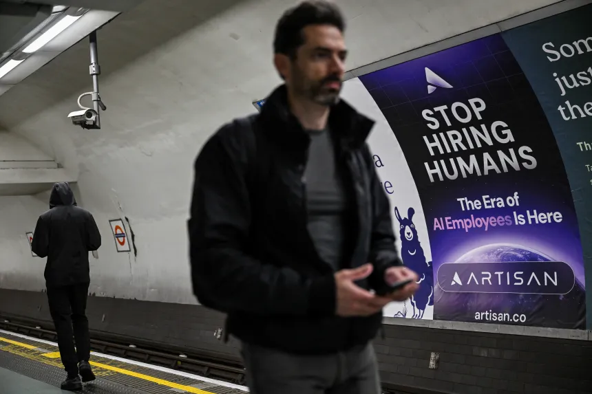 En mann går forbi en reklame på undergrunnen i London