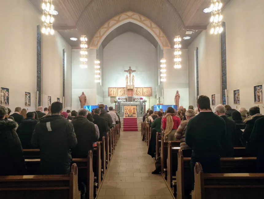 Troende ser på biskop Fredrik Hansens bispevielse på store skjermer i St. Joseph kirke