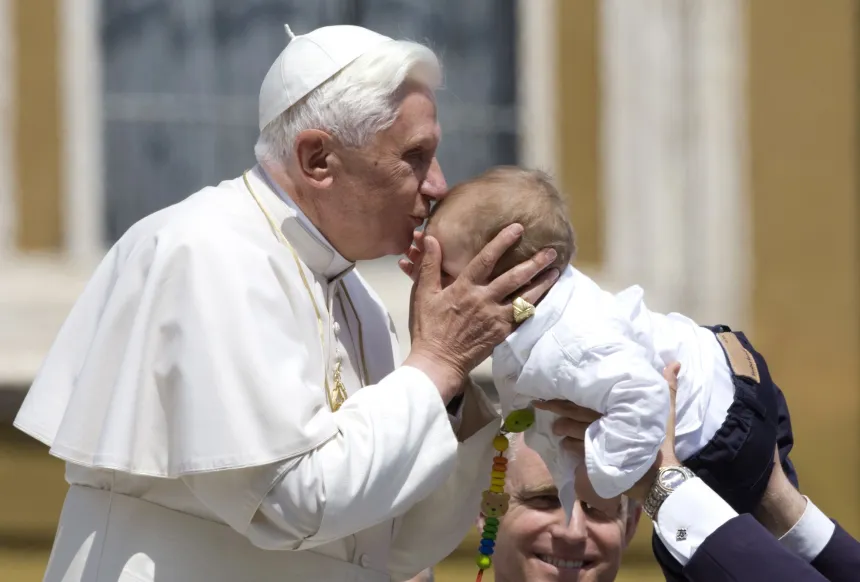 Pave Benedikt XVI kysser et barn på Petersplassen