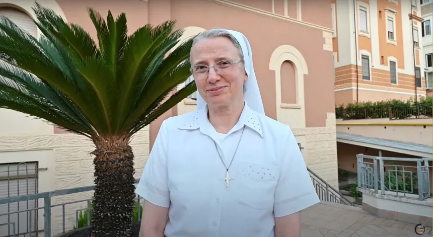 Sr. Simona Brambilla, kledd i hvit, utenfor en bygning i Roma