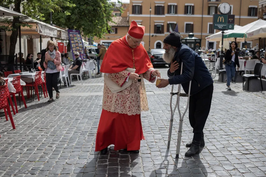 En kardinal gir penger til en tigger i Roma