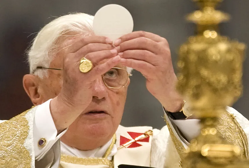 Pave Benedikt XVI løfter hostien under en messe