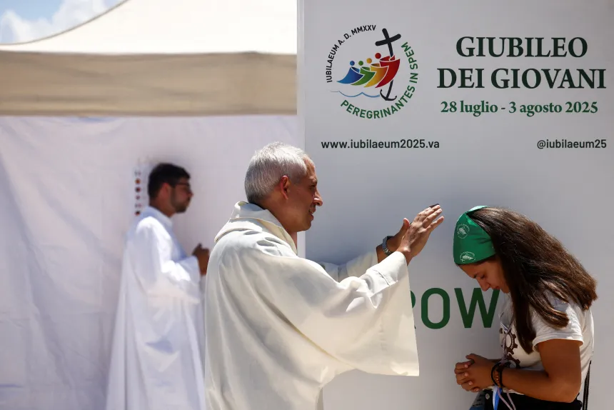 En prest velsigner en ung kvinne under jubelårsfeiringen for ungdom i Roma