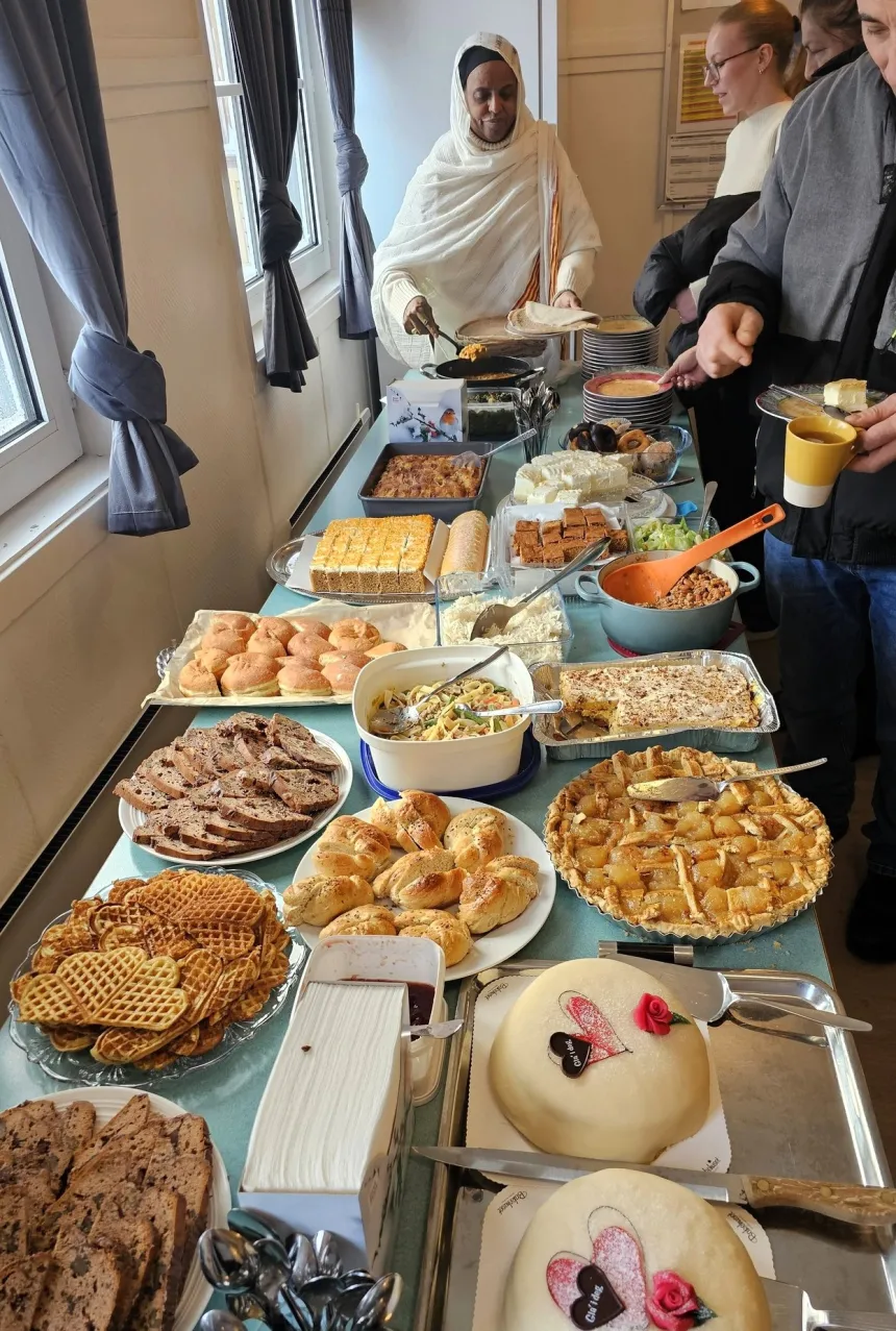 Kakebord dekket med kaker, vafler, muffins og boller.