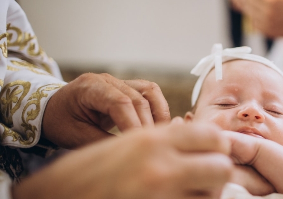 Child baptised in church by priest