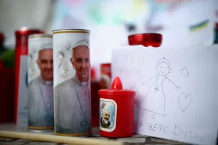 To lys med bilde av pave Frans ved siden av en barnetegning av paven