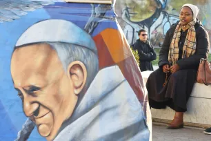 En kvinne ber rosenkransen ved siden av et bilde av pave Frans utenfor Gemelli-sykehuset